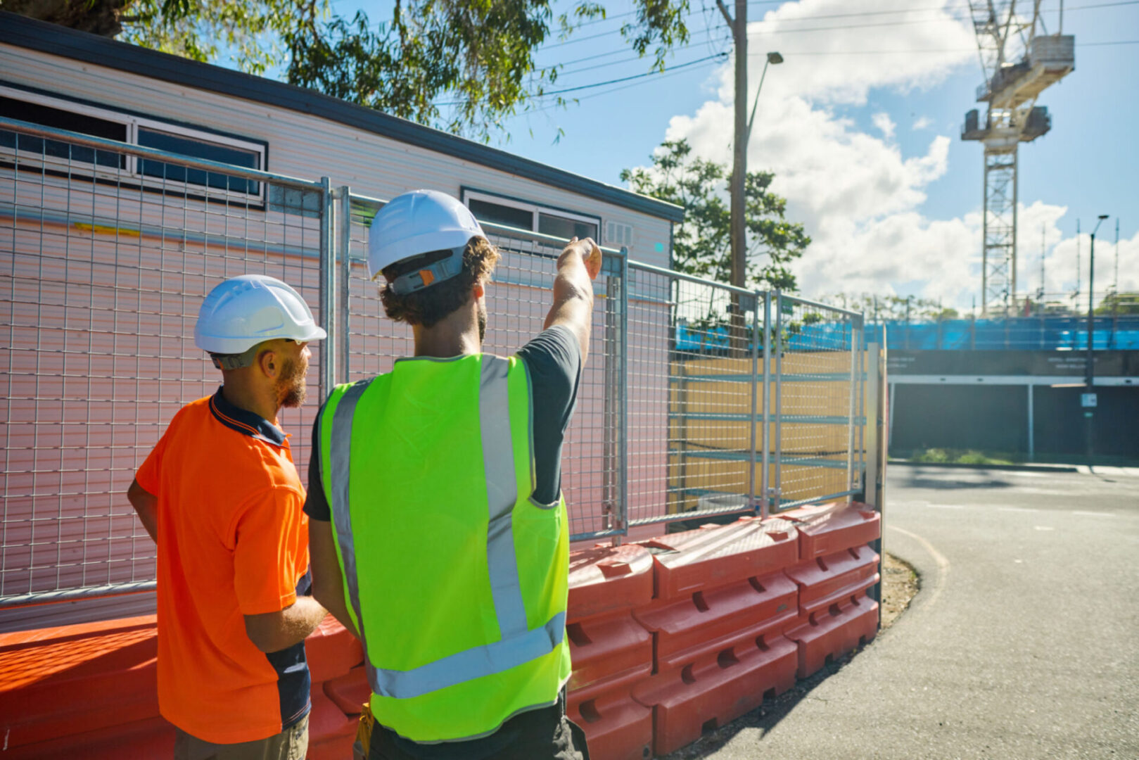 Construction workers discussing site plans outdoors.
